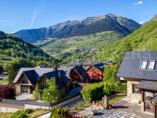 Mountain view home with slate roof and large windows.
