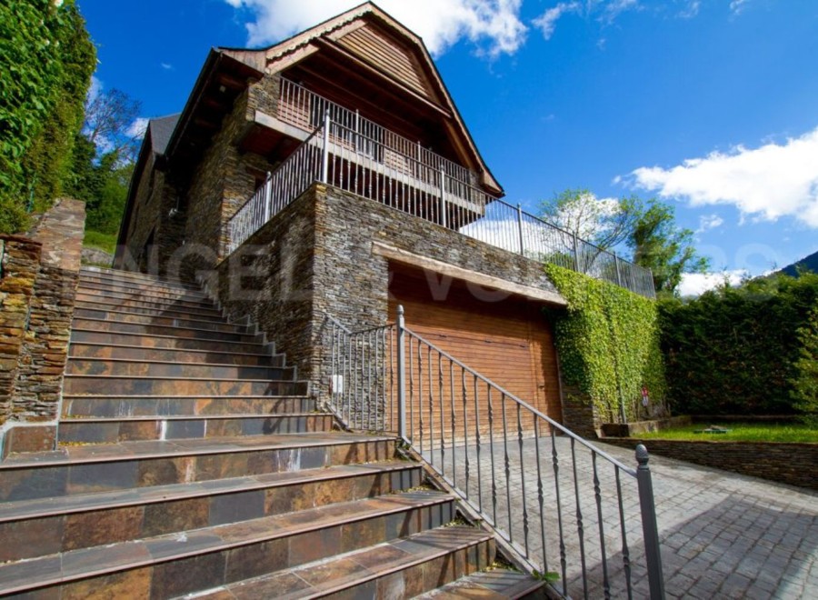 Mountain retreat with stone and wood exterior, offering stunning views.