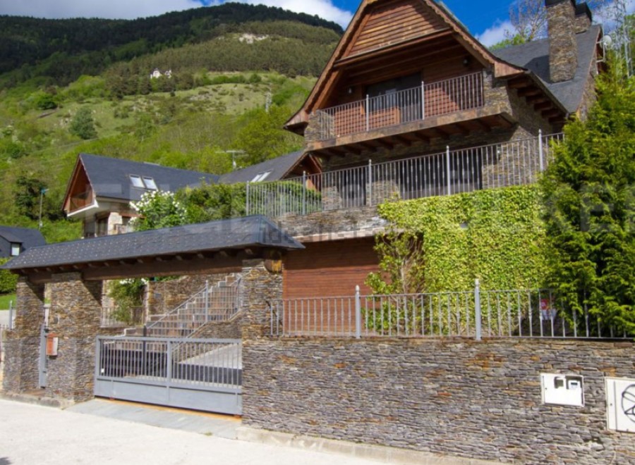 Mountainside home with stone and wood exterior, offering stunning views.