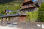 Mountainside home with stone and wood exterior, offering stunning views.