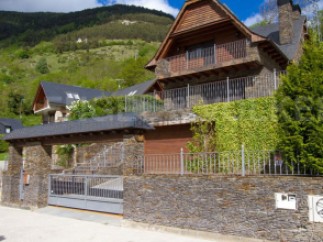 Mountainside home with stone and wood exterior, offering stunning views.