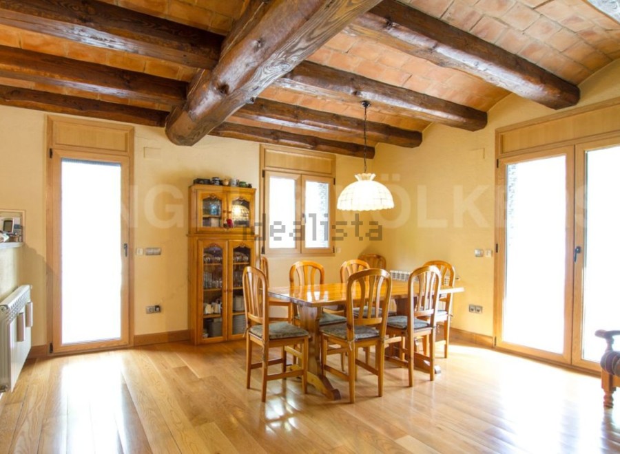 This stunning property boasts a spacious dining area with a rustic wooden table and chairs, perfect for family gatherings.