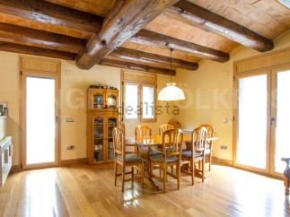 This stunning property boasts a spacious dining area with a rustic wooden table and chairs, perfect for family gatherings.