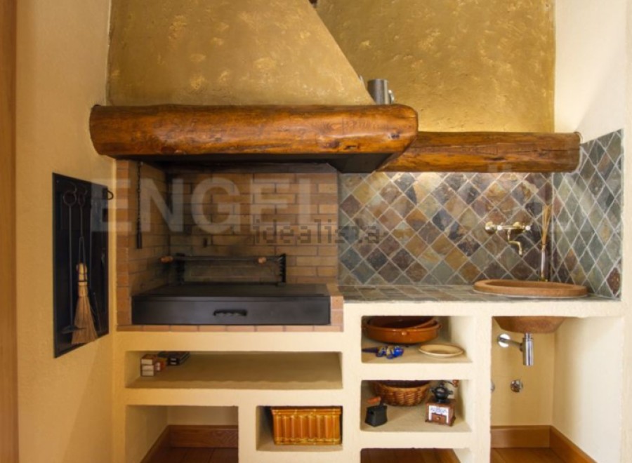 This stunning property boasts a built-in outdoor kitchen, complete with a traditional wood-fired grill and ample storage.
