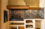 This stunning property boasts a built-in outdoor kitchen, complete with a traditional wood-fired grill and ample storage.