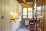 This stunning laundry room boasts custom cream cabinets, a built-in sink, and high-end washer and dryer.