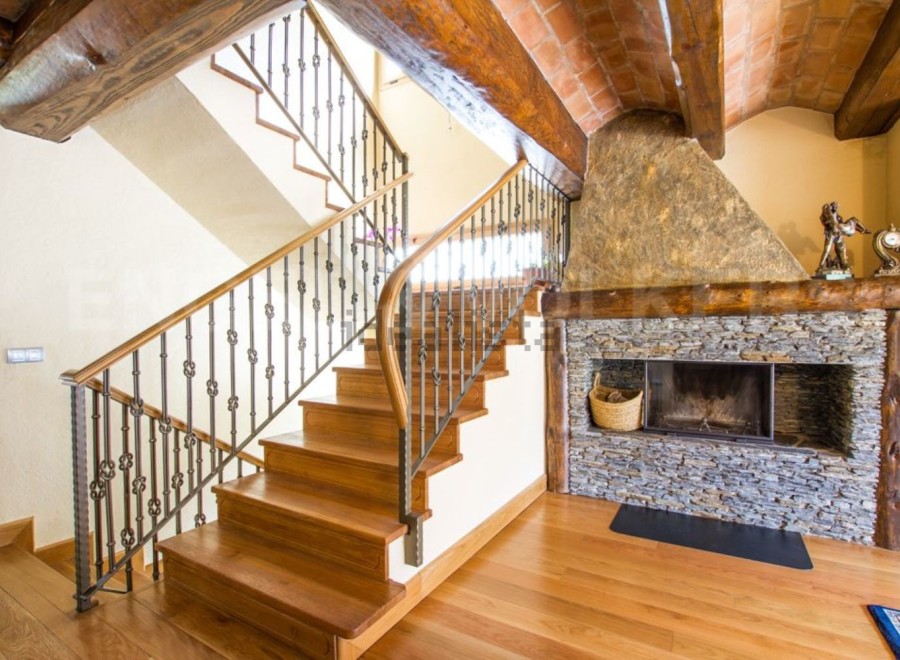 This stunning property boasts a grand wooden staircase with an intricate metal railing, adding elegance to the home.
