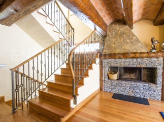 This stunning property boasts a grand wooden staircase with an intricate metal railing, adding elegance to the home.