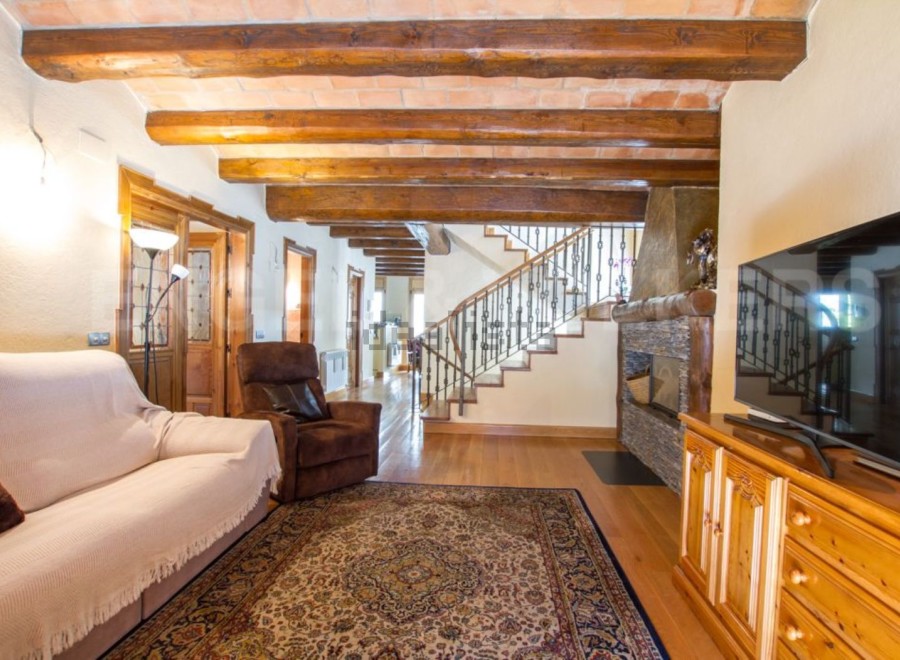 This stunning property boasts a spacious living area with exposed wooden beams, creating a warm and inviting atmosphere.