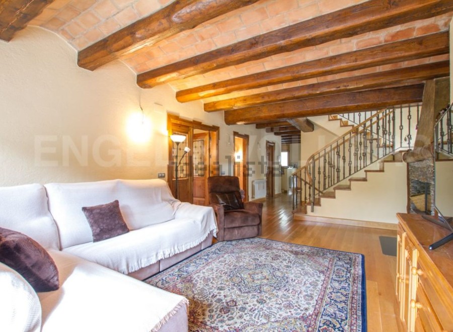 This stunning property boasts a spacious living area with exposed wooden beams and a cozy atmosphere.