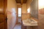 Charming rustic bathroom with terracotta tile and wooden accents.