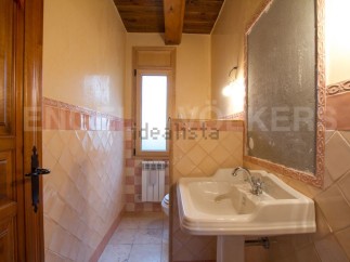 Charming rustic bathroom with terracotta tile and wooden accents.