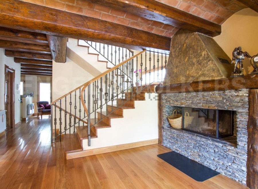 This stunning property boasts a beautiful wooden staircase with wrought iron railings, leading to an upper level.
