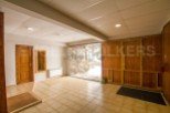 This spacious property boasts a large garage with wooden doors, providing ample storage space.