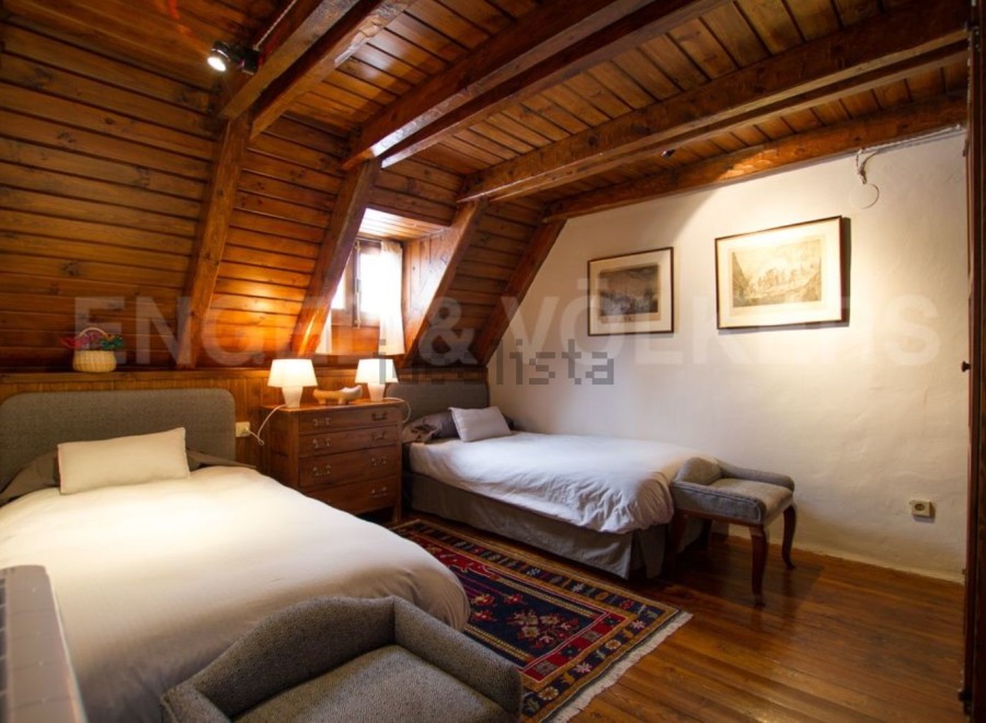 Charming attic bedroom with wooden beams and twin beds.