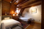 Charming attic bedroom with wooden beams and twin beds.