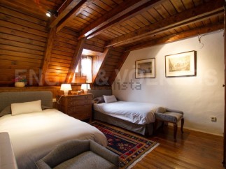 Charming attic bedroom with wooden beams and twin beds.