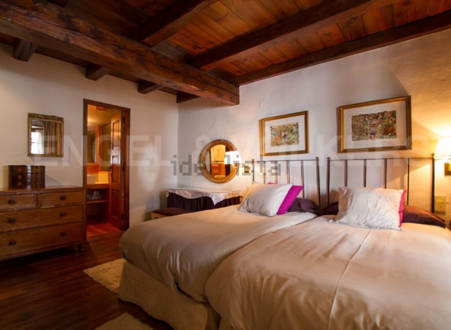 Charming rustic bedroom with wooden beams and exposed ceiling.