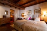 Charming rustic bedroom with wooden beams and exposed ceiling.