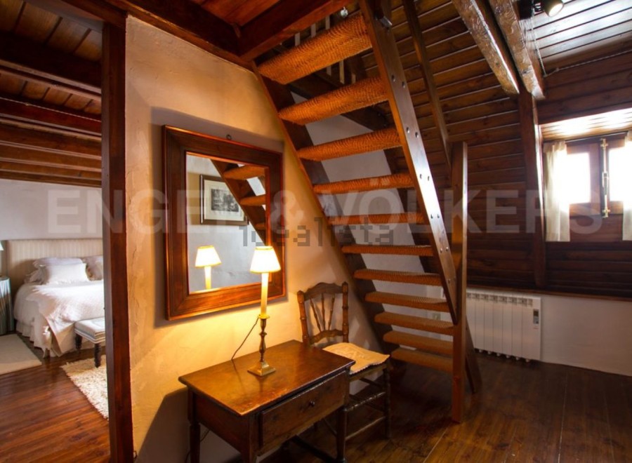 Charming rustic home with exposed wooden beams and a cozy wooden staircase.