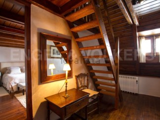 Charming rustic home with exposed wooden beams and a cozy wooden staircase.
