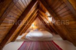Cosy attic bedroom with wooden beams and a comfortable double bed.