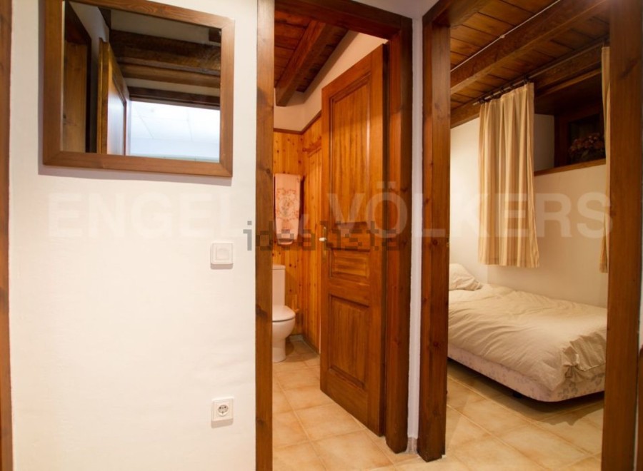 Charming wooden apartment with a cozy bedroom and a well-equipped bathroom.