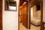 Charming wooden apartment with a cozy bedroom and a well-equipped bathroom.