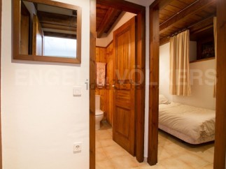 Charming wooden apartment with a cozy bedroom and a well-equipped bathroom.