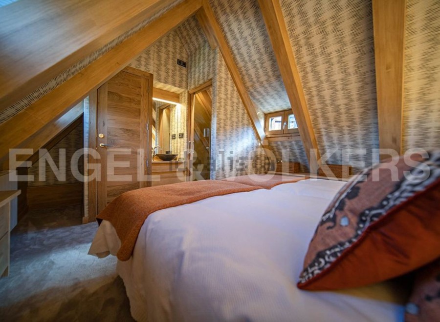 Cosy attic bedroom with wooden beams and stylish decor.