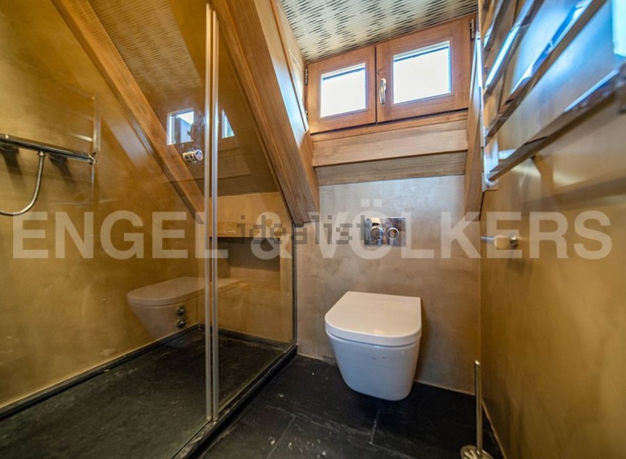 Luxury bathroom with a modern design, featuring a walk-in shower, toilet, and heated towel rack.