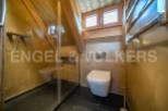 Luxury bathroom with a modern design, featuring a walk-in shower, toilet, and heated towel rack.