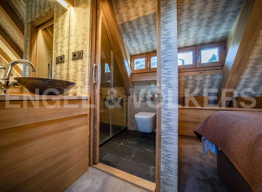 This stunning bathroom boasts a unique design with wooden finishes and a spacious shower.