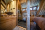 This stunning bathroom boasts a unique design with wooden finishes and a spacious shower.
