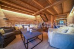 This stunning chalet boasts a spacious living area with exposed wooden beams and a cozy atmosphere.