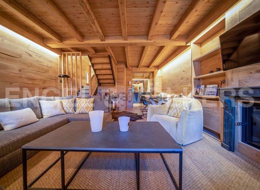 This stunning chalet boasts a spacious living area with a cozy fireplace, perfect for relaxing after a day on the slopes.