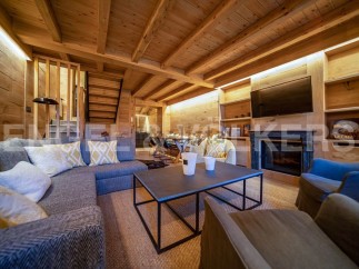 This stunning chalet boasts a spacious open-plan living area with a cozy fireplace, perfect for relaxing after a day on the slopes.
