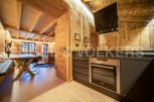 This stunning chalet boasts a beautiful open-plan living area with a rustic wooden dining table and comfortable seating.