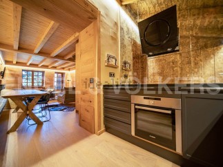 This stunning chalet boasts a beautiful open-plan living area with a rustic wooden dining table and comfortable seating.