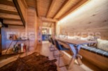 This stunning chalet boasts a unique wooden interior with exposed beams and a cozy built-in bench seating area.