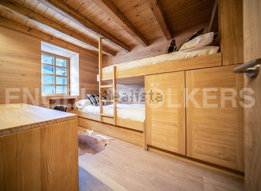 Charming wooden bunk beds with built-in storage create a cozy and functional space.