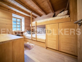 Charming wooden bunk beds with built-in storage create a cozy and functional space.