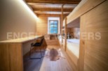 Cozy chalet bedroom with built-in bunk beds and a small workspace.
