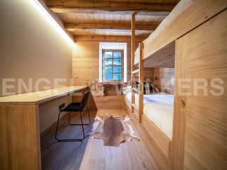 Cozy chalet bedroom with built-in bunk beds and a small workspace.
