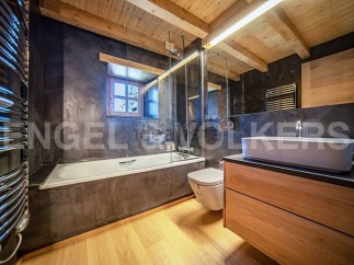 This stunning bathroom boasts a sleek, modern design with a freestanding bathtub and a spacious vanity.