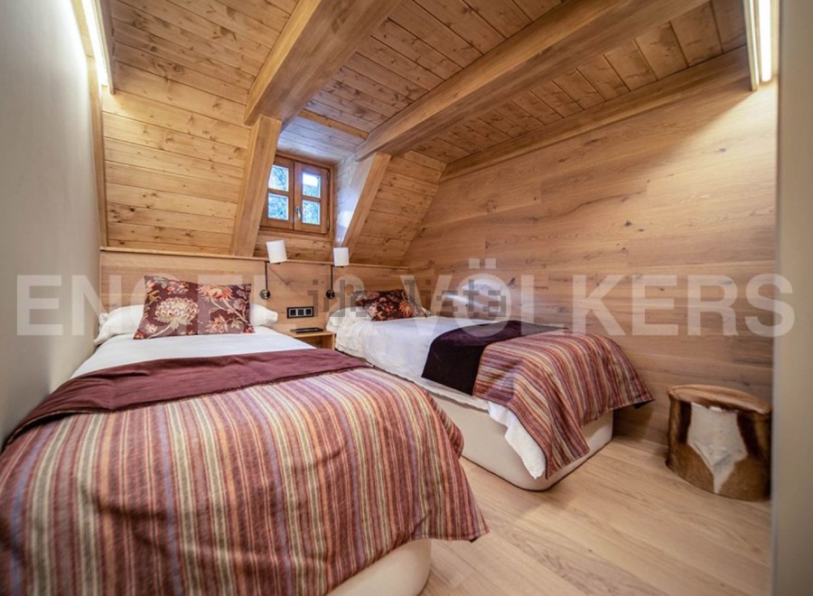 Cozy chalet bedroom with twin beds and wooden walls.