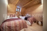 Cozy chalet bedroom with twin beds and wooden walls.