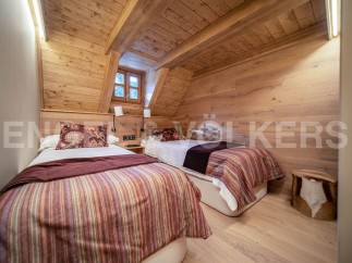 Cozy chalet bedroom with twin beds and wooden walls.
