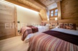 Cozy chalet bedroom with twin beds, wooden beams, and a rustic feel.