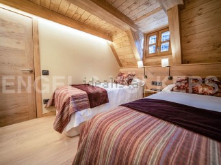 Cozy chalet bedroom with twin beds, wooden beams, and a rustic feel.